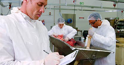 Male butcher writing on clipboard