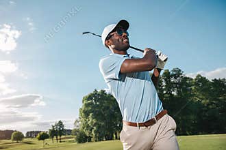 African american man in cap and sunglasses playing golf