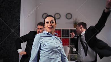 We happy of Friday ending businesspeople dancing cheerfully in office in front of the camera.