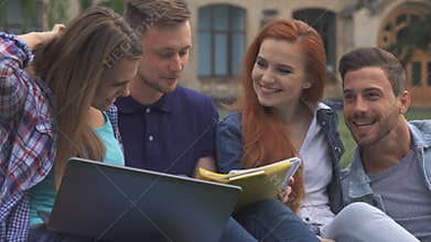 Students discuss something on the lawn on campus