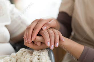 Caregiver holding senior woman`s hands