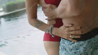 Two lovers hug in the villa with the pool