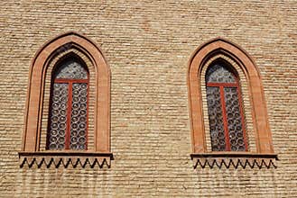 Castle window in a medieval style. Double arched window on a facade of medieval wall. Biforium - ancient window with