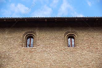 Castle window in a medieval style. Double arched window on a facade of medieval wall. Biforium - ancient window with