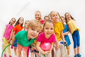 Sporty kids and gymnastics coach having fun in gym
