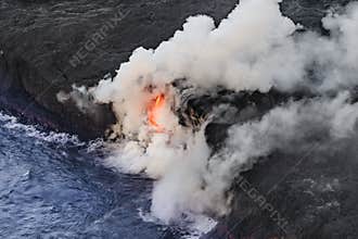 Aerial shot of KiÌ„lauea lava tube entering the sea