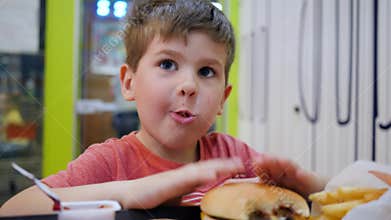 Oily food in school cafeteria for lunch, Small boy eats with appetite in small childrens restaurant, Beautiful baby