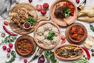 A lot of food on the wooden table. Georgian cuisine. Top view. Flat lay . Khinkali and Georgian dishes
