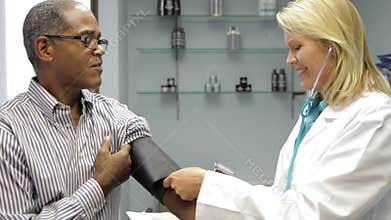 Doctor Checking Male Patient's Blood Pressure