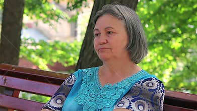 Sad old woman in the park