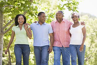 Two couples walking outdoors arm in arm smiling
