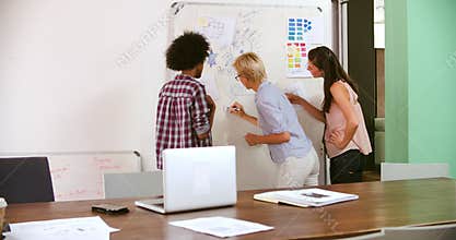 Three Businesswomen Having Brainstorming Meeting In Office