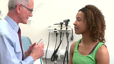 Doctor Giving Female Patient Health Check In Surgery