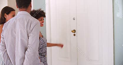 Man Welcoming Visiting Friends At Front Door