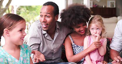 Group Of Families At Home On Patio Talking Together