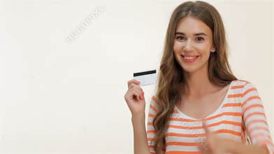 Attractive girl showing thumbs-up with credit card