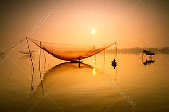 Unidentified fisherman checks his nets in early morning on river in Hoian, Vietnam
