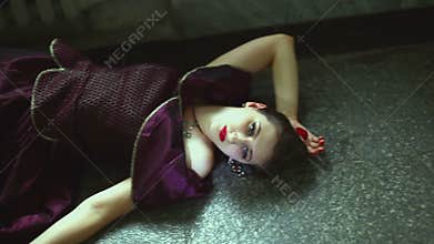 Gothic girl lying on the floor with his eyes open.
