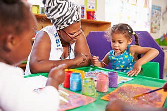 Teacher sitting with kids in a preschool class, close up