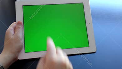 Woman using digital tablet with a green screen