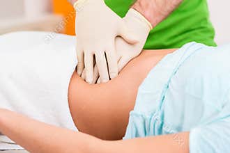 Practitioner at colon therapy massaging abdomen