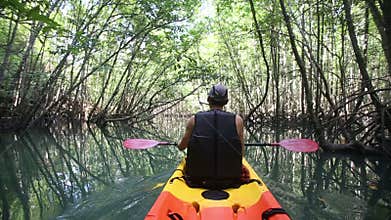 man boating in kayak along lagoon