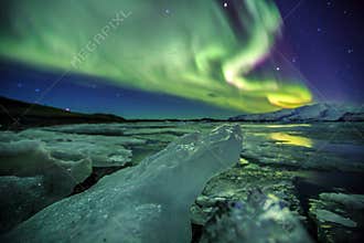 Auroral over the glacier lagoon Jokulsarlon in Iceland.