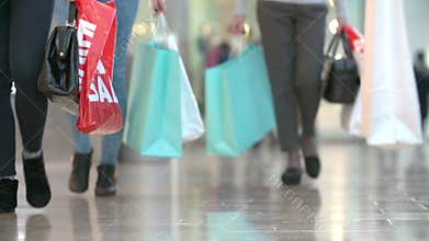 Close Up Of Shopper's Feet Carrying Bags In Shopping Mall