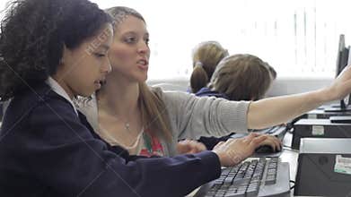 Teacher Helping Female Pupil In Computer Class