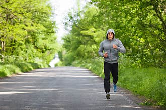 Runner man running on road training sprint. Sporting male run working out outside