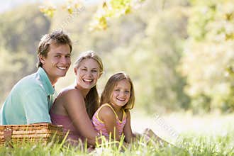 Family at park having a picnic and smiling