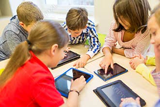 Group of school kids with tablet pc in classroom