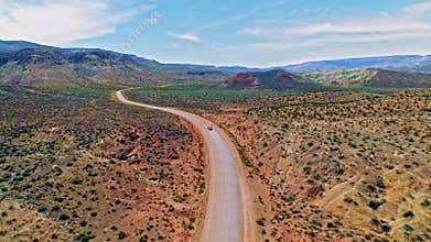 Car driving on a dirt road through dry Arizona desert