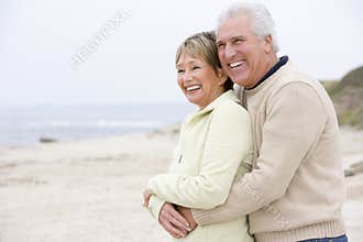 Couple at the beach embracing and smiling