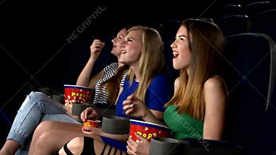 Girl watching ÑÐ°medy film at the cinema, eating