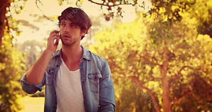 Handsome man having a phone call in the park
