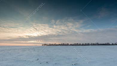 Timelapse. Russia. The movement of the clouds at sunset in the snowy steppe in winter.