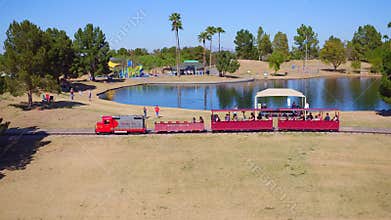 People Riding a Train Around a Lake at a Park