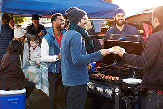 Group Of Sports Fans Tailgating In Stadium Car Park