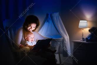 Mother reading a book to little baby