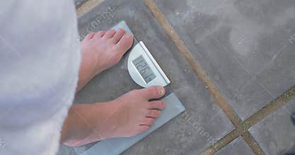 Man weighing himself on bathroom scales