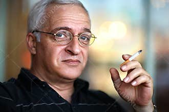 Elderly man smoking cigarette.