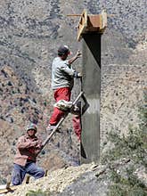 Construction workers building concrete structure in mountainous Nepal.