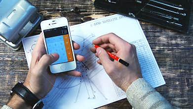 Man using smart phone as a calculator to calculate the value of the figure