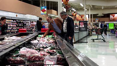 People selecting meat in grocery store