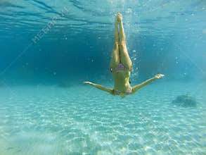 Good looking woman diving under the sea