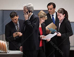 Co-workers in crisis meeting in cubicle