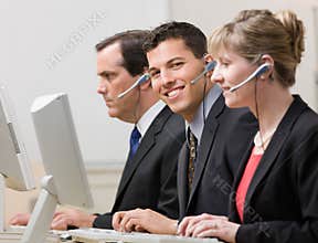 Co-workers working at computers in call center