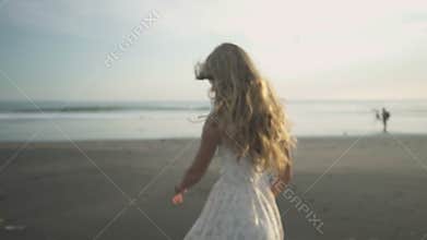 Carefree woman dancing in the sunset on the beach