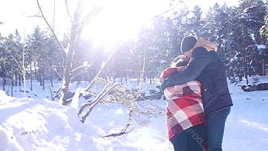 Young and beautiful couple in love walking in the winter woods